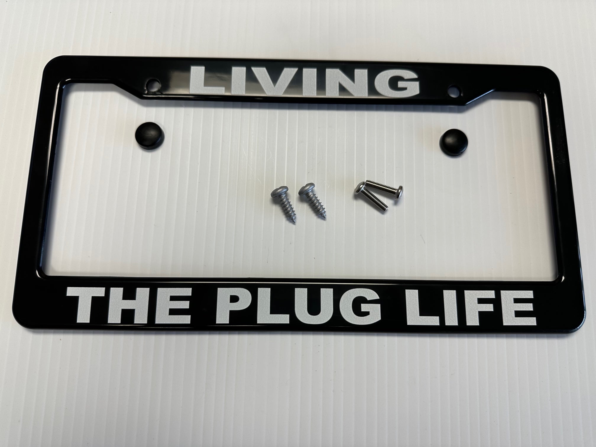 Electric Car "EV" License Plate Frame, "LIVING THE PLUG LIFE", Black