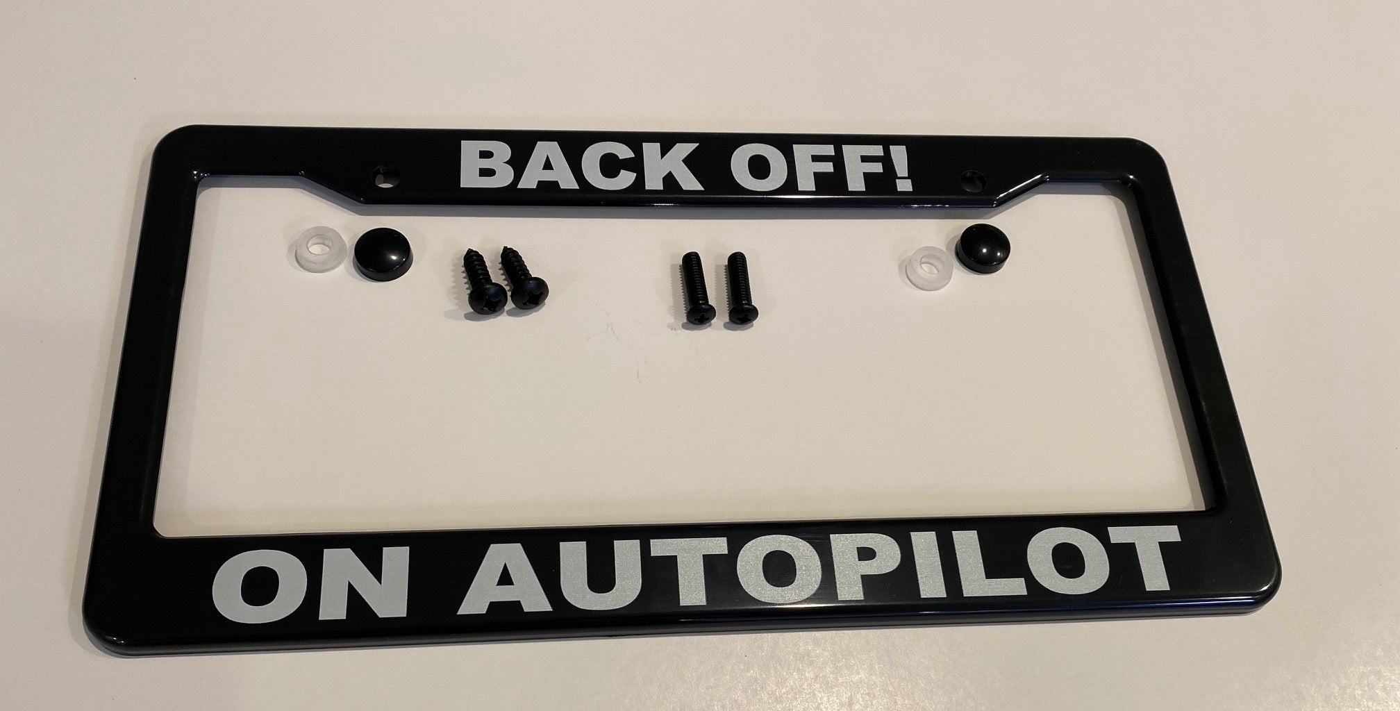 Tesla Model S, 3, X, Y, Cybertruck Black ABS License Plate Frame with lettering "BACK OFF! ON AUTOPILOT"